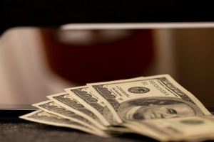 Fanned out hundred dollar bills, saving money.